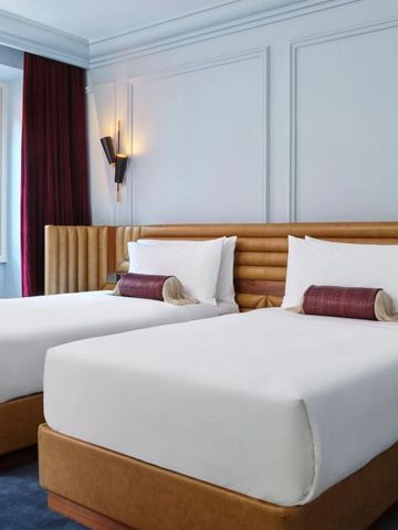 Helles Hotelzimmer mit zwei Betten und Fenster mit Ausblick