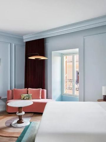 Helles Zimmer mit Sitzbereich, Kunstwerken und großem Bett