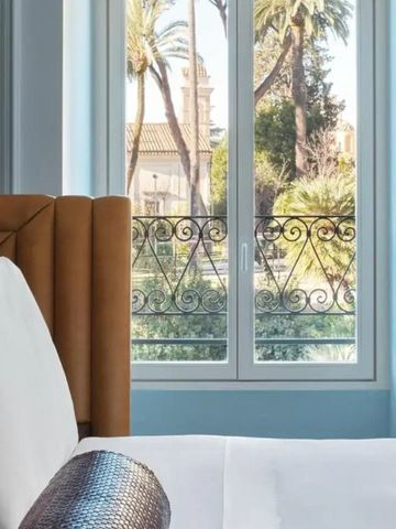 Hotelzimmer mit Fensterblick auf Palmen und Garten