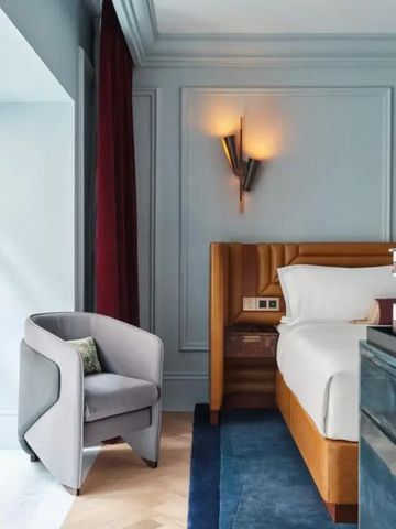 Elegantes Hotelzimmer mit gemütlichem Sessel und gedämpfter Beleuchtung.