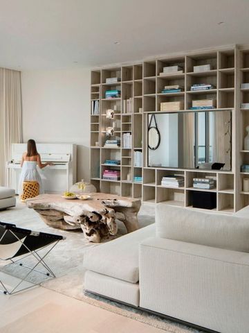 Wohnzimmer mit Bücherregal und Klavier in moderner Einrichtung