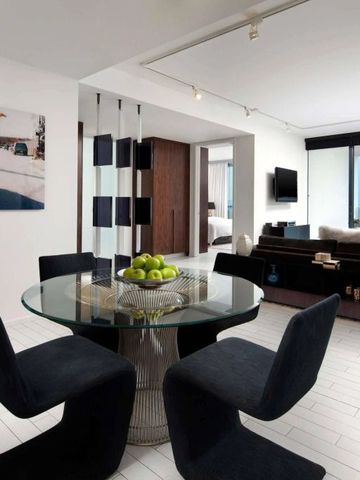 Eleganter Wohnbereich einer Suite mit Glas-Esstisch und Meerblick