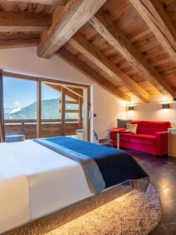 Geräumiges Hotelzimmer mit Holzdecke und Balkon mit Bergblick