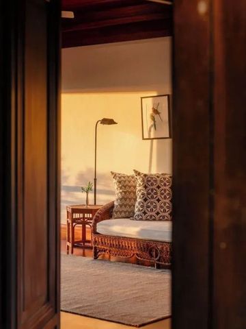 Gemütlicher Wohnbereich mit stilvoller Beleuchtung und Kissen bei Sonnenuntergang