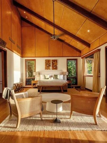 Geräumiges Schlafzimmer mit Holzdetails und komfortabler Sitzecke