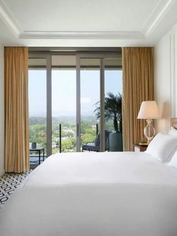 Helles Hotelzimmer mit Panoramablick und großem Bett