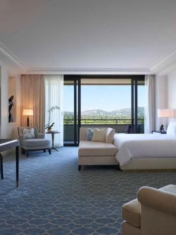 Elegantes Hotelzimmer mit großem Bett und Balkon mit Aussicht in Beverly Hills