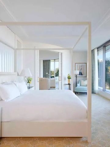 Modernes Hotelzimmer mit Himmelbett und großen Fenstern