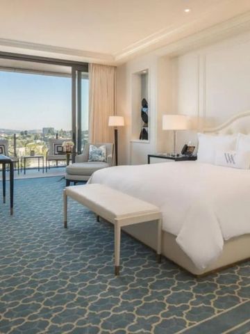 Luxuriöses Schlafzimmer mit großem Bett und Fenster mit Stadtpanorama