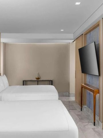 Hotelzimmer mit zwei Betten, dezente Beleuchtung und minimalistisches Design