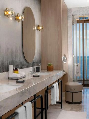 Luxuriöses Badezimmer mit Doppelwaschbecken und Blick aufs Meer