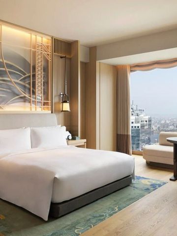 Luxuriöses Hotelzimmer mit großem Bett und weitem Stadtblick