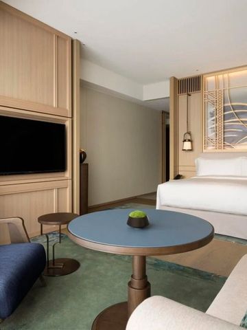 Modernes Hotelzimmer mit großem Bett und Wohnbereich