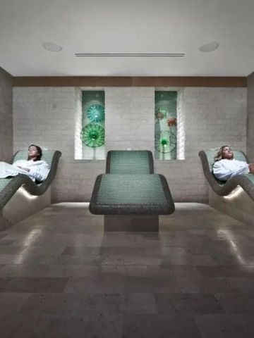 Menschen entspannen auf beheizten Steinliegen im Spa