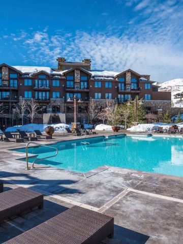 Außenpool mit Blick auf die Hotelgebäude und Schneeberge