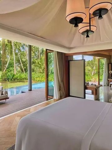 Luxuriöses Schlafzimmer mit Blick auf den privaten Pool und üppige Vegetation