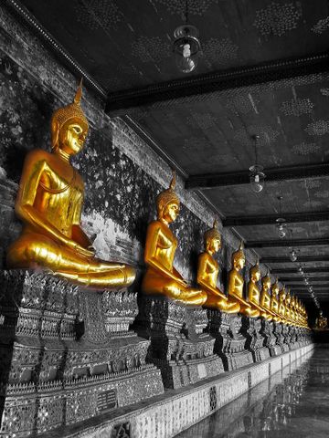 m Wat Suthat stehen eindrucksvolle, kunstvoll verzierte Statuen, die mit ihren feinen Details und würdevollen Gesten die spirituelle Atmosphäre des Tempels unterstreichen.