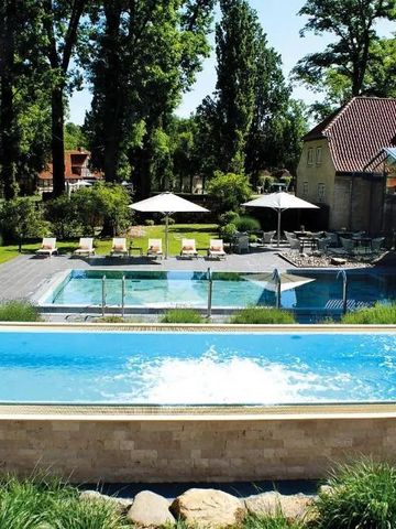 Außenbereich mit Pool, Liegen und grünem Garten