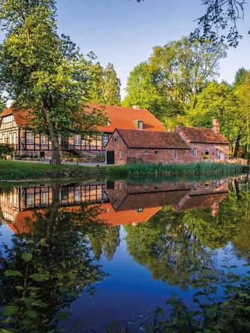 Historisches Gebäude an einem ruhigen Teich im Grünen
