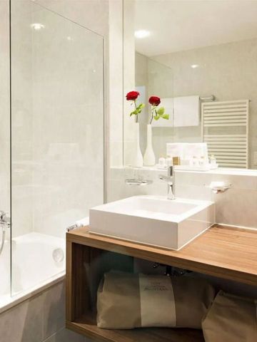 Helles Badezimmer mit Badewanne und stilvoller Dekoration