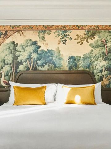Luxuriöses Hotelzimmer mit kunstvollem Wandteppich und goldenen Akzenten