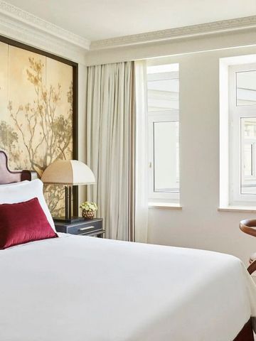 Hotelzimmer mit einem großen Bett und zwei Fenstern für viel Tageslicht