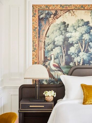 Detail einer luxuriösen Zimmerdekoration mit Kunstwerk an der Wand und elegantem Nachttisch.