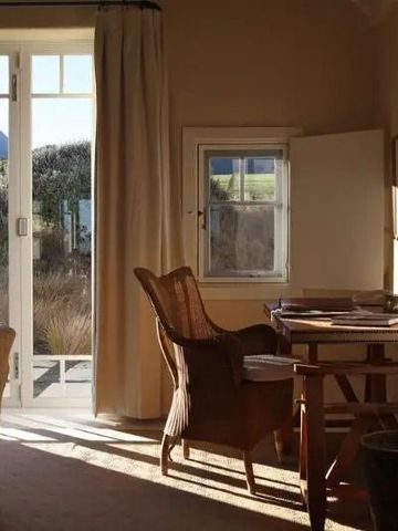 Sonniger Raum mit Schreibtisch und Blick auf die Landschaft