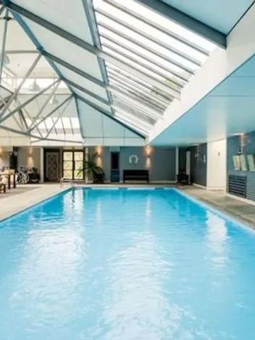 Luxuriöser Innenpool mit Glasdach und Liegen neben dem Becken.