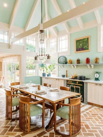 Helle und geräumige Küche mit großem Esstisch und hohen Fenstern