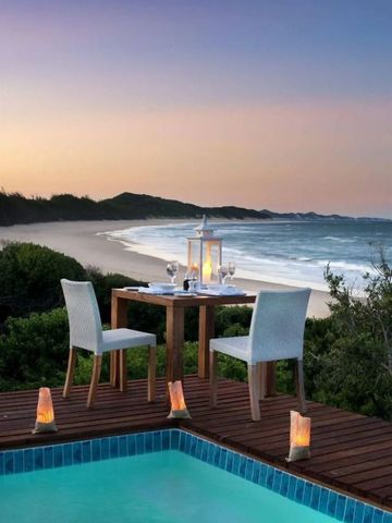 Romantisches Abendessen auf einer Terrasse mit Blick auf den Strand bei Sonnenuntergang