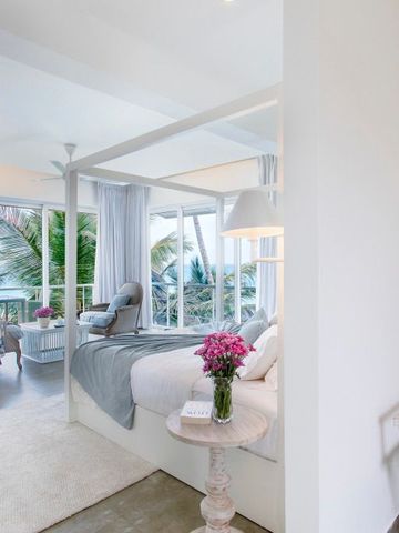 Helles Hotelzimmer mit Himmelbett und Meerblick