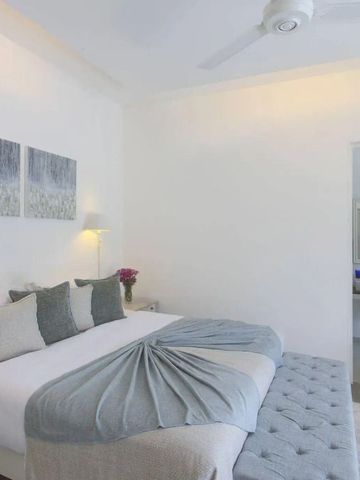 Geräumiges Schlafzimmer mit elegantem Doppelbett und dezenter Dekoration