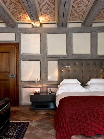 Gemütliches Schlafzimmer mit Holzbalkendecke und warmem Farbton