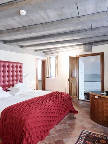 Zimmer mit rotem Kopfteil und Holzbalkendecke
