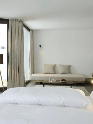 Helles Hotelzimmer mit großen Fenstern und modernem Design im Hotel Wiesergut.