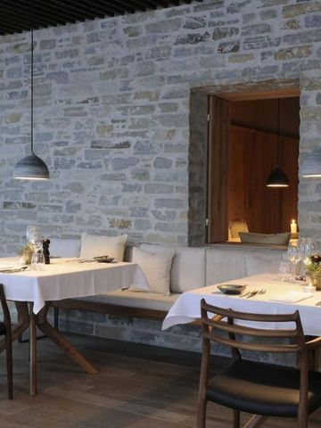 Rustikales Restaurant mit Steinwänden und gemütlichen Esstischen