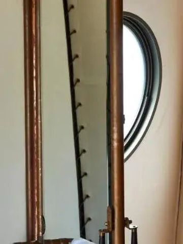 Badezimmerdetail mit eleganter Duscharmatur und rundem Fenster.