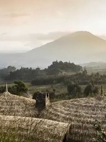Atemberaubende Berglandschaft bei Sonnenuntergang mit traditionellem Dach im Vordergrund