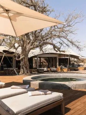 Terrasse mit Sonnenliegen und Tauchbecken in der Wüstensavanne