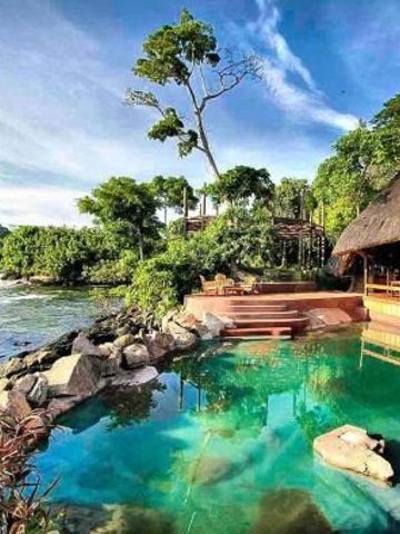 Infinity Pool mit Blick auf Fluss und üppige Vegetation