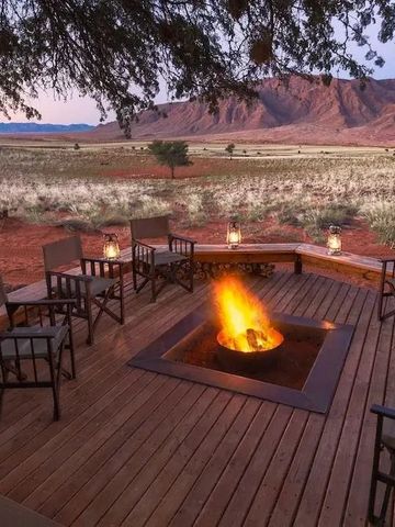 Feuerstelle auf Holzterrasse mit Blick auf Wüstenlandschaft