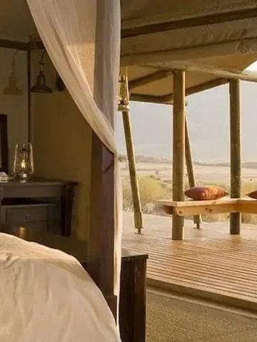 Luxuriöses Zelt mit Himmelbett und Blick auf die Dünen