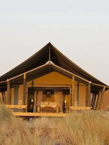 Gemütliches Zelt des Wolwedans Dune Camp inmitten der Wüstenlandschaft.