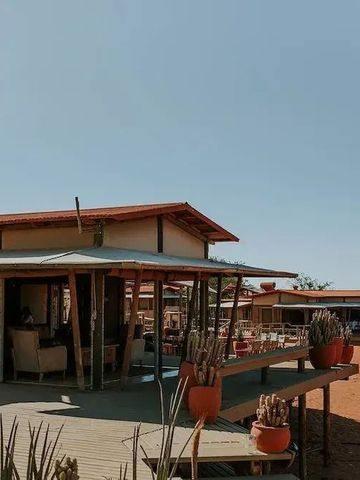 Außenansicht der Anlage des Wolwedans Dune Camps mit hölzernen Strukturen.