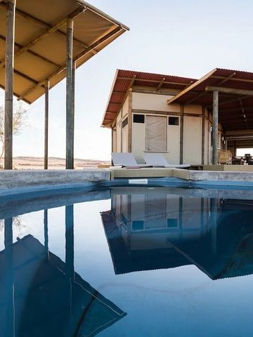 Außenansicht mit Pool und modernen Bungalows in der Wüste