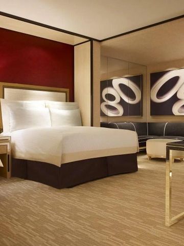 Elegantes Doppelzimmer mit roter Akzentwand und stilvollen Möbeln.