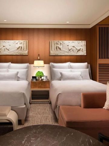 Geräumiges Zimmer mit zwei Doppelbetten und warmen Holzakzenten.