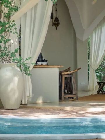 Offener Lounge-Bereich mit Vorhängen und Blick auf den Garten