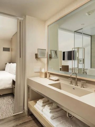 Modernes Badezimmer einer Suite mit großem Spiegel